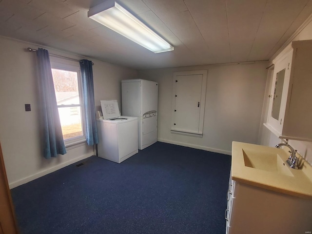 clothes washing area with washer / clothes dryer, dark colored carpet, and sink