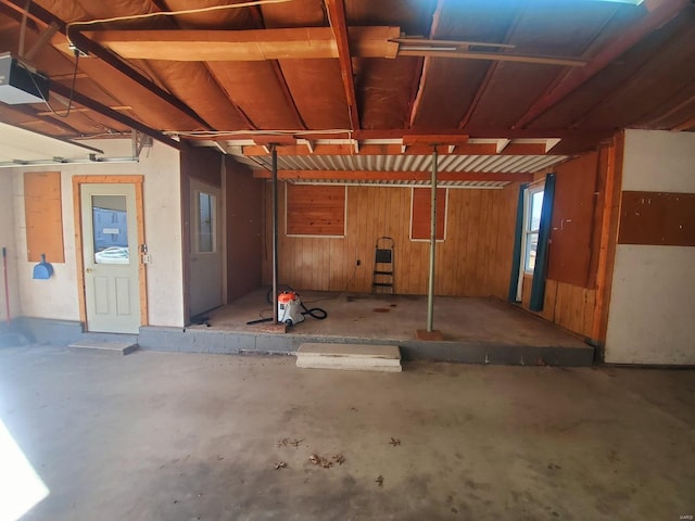 garage with a garage door opener and wooden walls