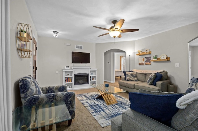 living room with ceiling fan and carpet