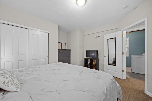 bedroom with independent washer and dryer, a closet, and carpet