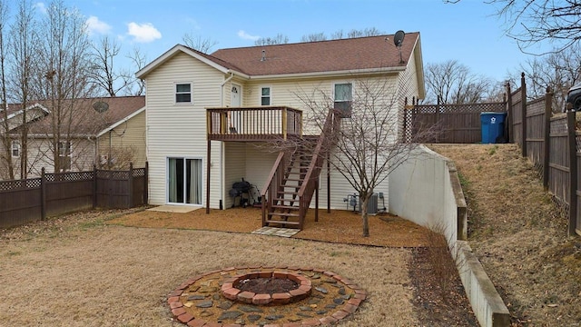 rear view of house featuring a wooden deck, a fire pit, and central air condition unit