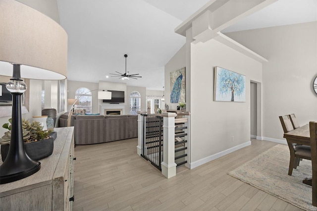 kitchen featuring ceiling fan, high vaulted ceiling, and light wood-type flooring