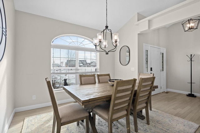 dining room featuring an inviting chandelier, lofted ceiling, and light hardwood / wood-style floors