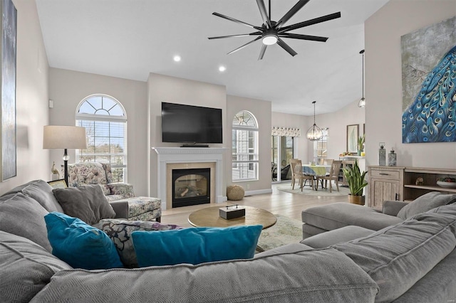 living room with light hardwood / wood-style flooring, high vaulted ceiling, and a chandelier