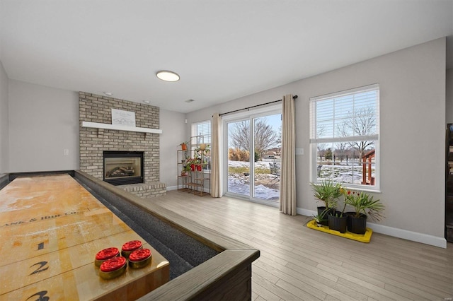 recreation room with wood-type flooring and a brick fireplace