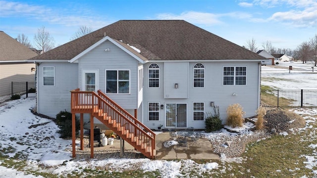 view of snow covered back of property