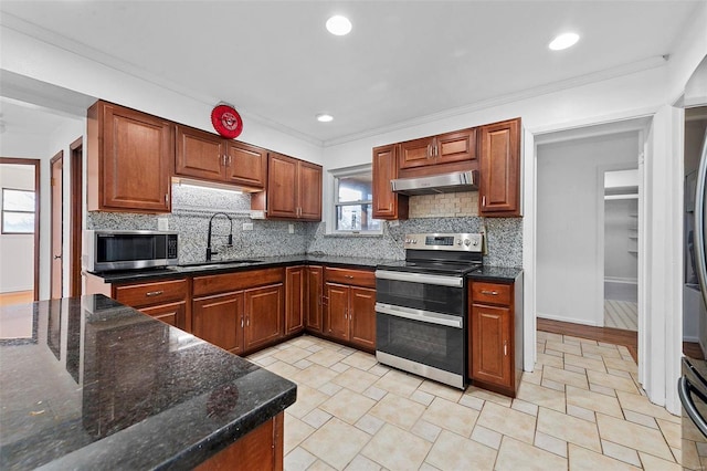 kitchen featuring sink, dark stone countertops, backsplash, stainless steel appliances, and crown molding