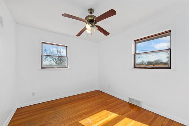 spare room with hardwood / wood-style flooring, plenty of natural light, and ceiling fan