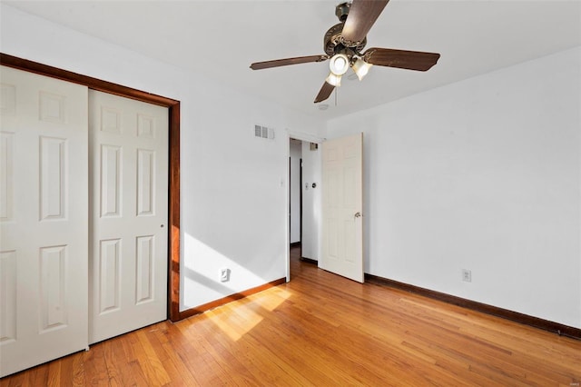 unfurnished bedroom featuring ceiling fan, light hardwood / wood-style floors, and a closet