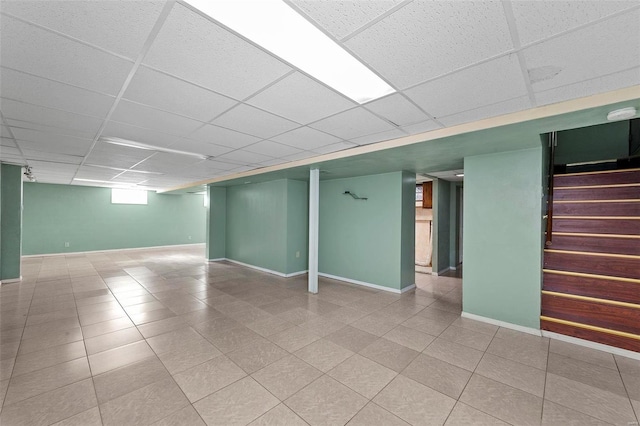 basement featuring a paneled ceiling and tile patterned floors