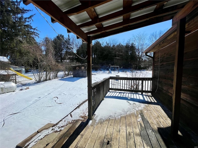 snow covered deck featuring a shed and an outdoor structure