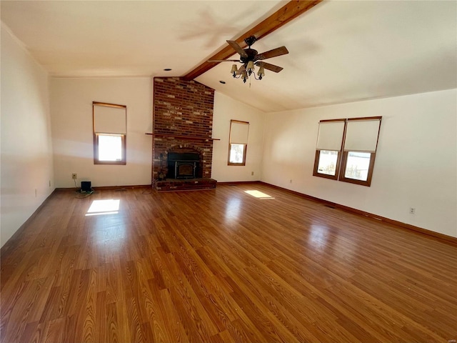 unfurnished living room featuring vaulted ceiling with beams, a ceiling fan, baseboards, and wood finished floors