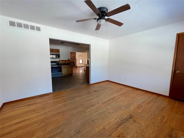 unfurnished room featuring baseboards, visible vents, ceiling fan, and dark wood-style flooring