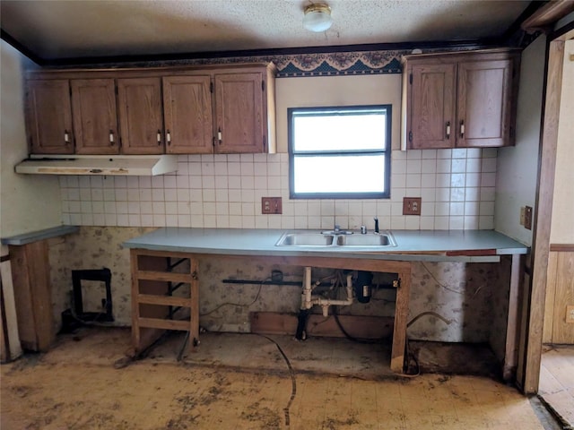 kitchen with sink, backsplash, and a textured ceiling