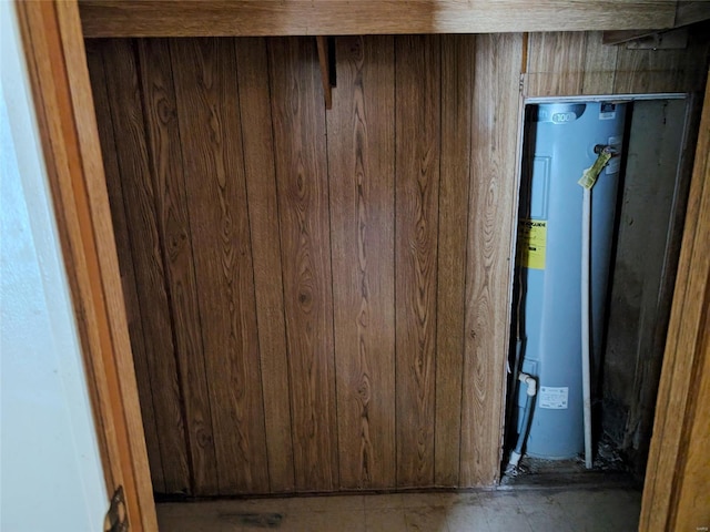 basement with water heater and wooden walls