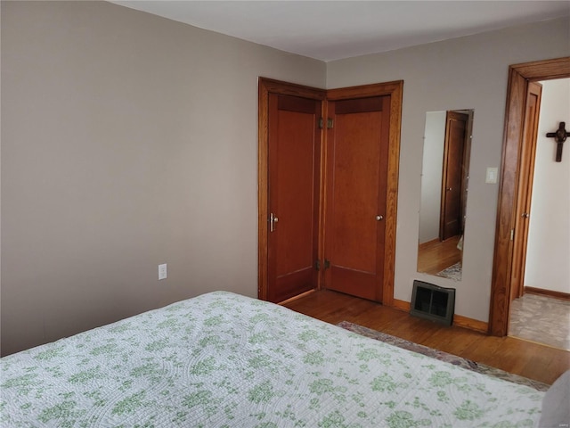 bedroom with dark hardwood / wood-style flooring and a closet