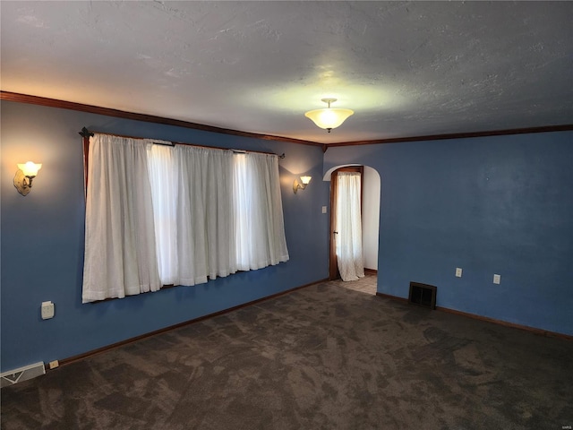 empty room with ornamental molding, a textured ceiling, and carpet flooring