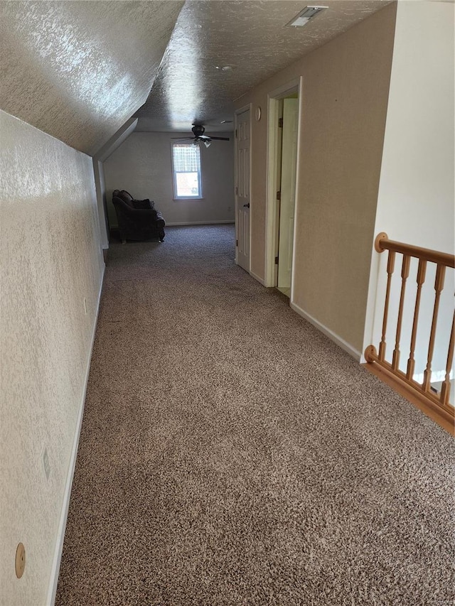 bonus room with lofted ceiling, a textured ceiling, and carpet