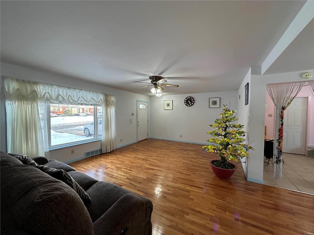 living room featuring ceiling fan and light hardwood / wood-style floors