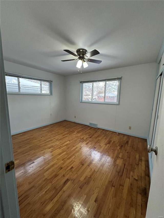 unfurnished room with ceiling fan and wood-type flooring