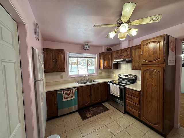 kitchen featuring light tile patterned flooring, stainless steel appliances, sink, and backsplash