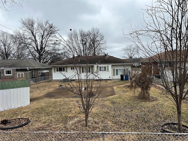 rear view of house featuring a storage shed