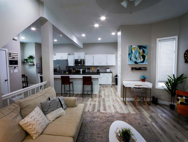 living room with ceiling fan and light wood-type flooring