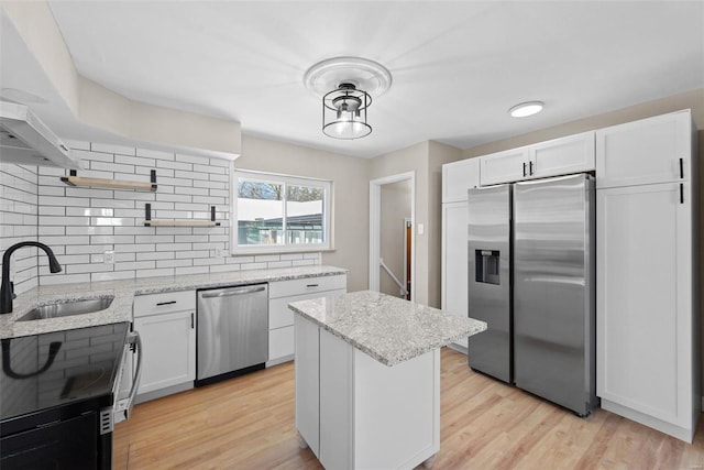 kitchen with open shelves, appliances with stainless steel finishes, a sink, and white cabinets