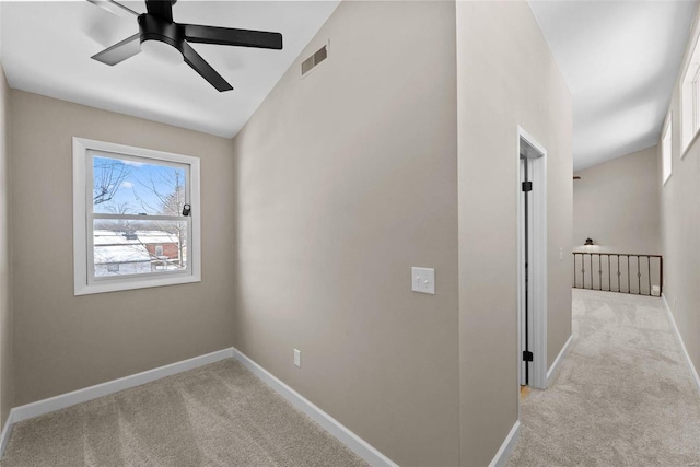 interior space with light colored carpet, ceiling fan, visible vents, and baseboards