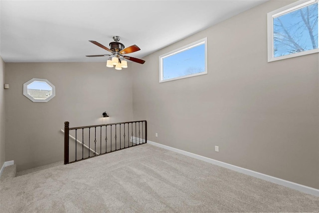 empty room featuring light carpet and baseboards