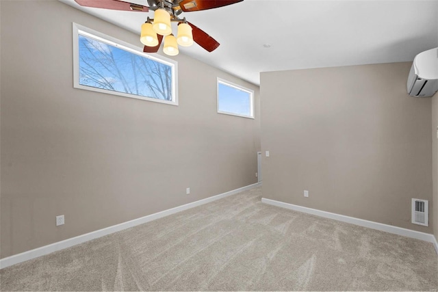 unfurnished room with visible vents, a wall mounted AC, a ceiling fan, light carpet, and baseboards