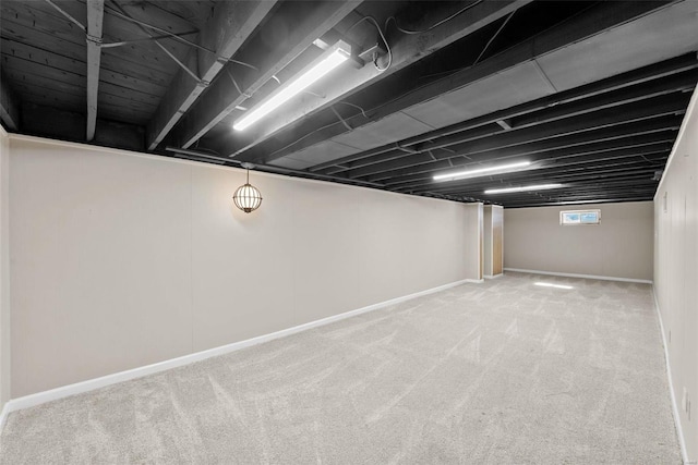 basement featuring light carpet and baseboards