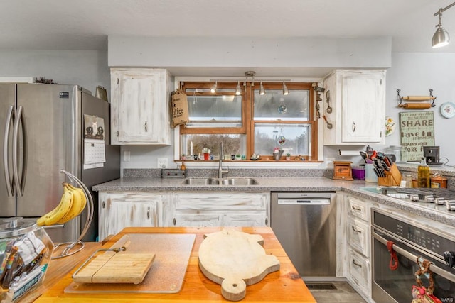 kitchen featuring appliances with stainless steel finishes, sink, and white cabinets