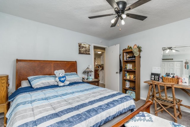 carpeted bedroom with ceiling fan and a textured ceiling