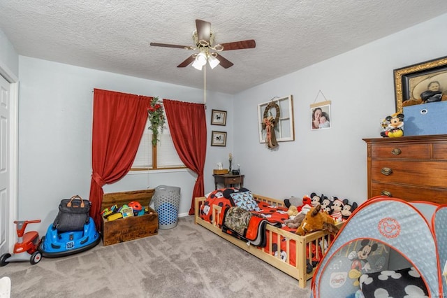 carpeted bedroom with ceiling fan and a textured ceiling