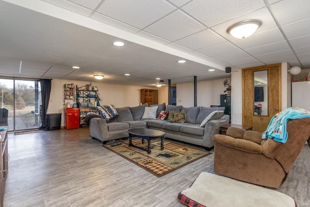 living room with wood-type flooring and a paneled ceiling