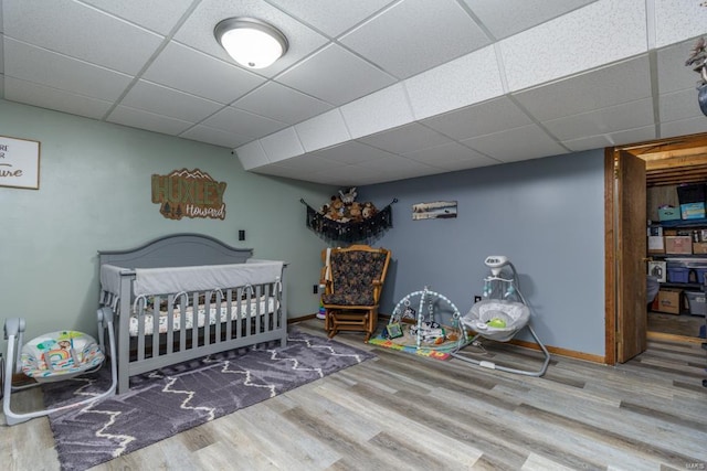 bedroom featuring hardwood / wood-style flooring and a paneled ceiling