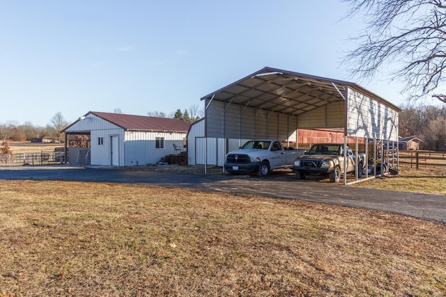 view of outbuilding featuring a carport and a lawn