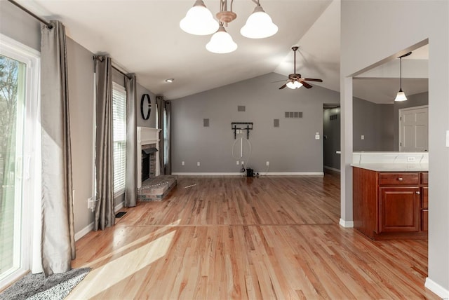 unfurnished living room with ceiling fan, lofted ceiling, and light wood-type flooring