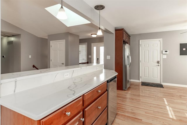 kitchen with a center island, light stone counters, stainless steel fridge with ice dispenser, decorative light fixtures, and light wood-type flooring