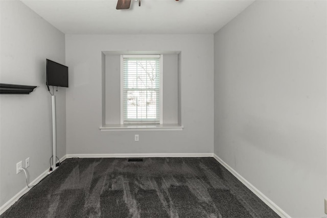 empty room featuring dark carpet and ceiling fan