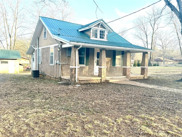 view of front facade featuring a porch, a storage unit, and central AC unit