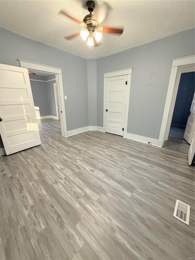 unfurnished bedroom featuring light hardwood / wood-style flooring, a closet, and ceiling fan