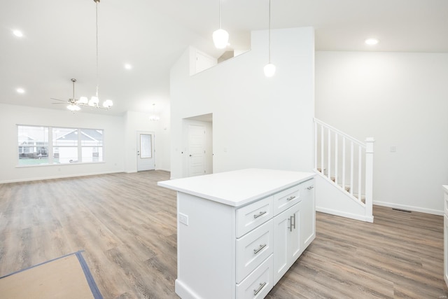 kitchen featuring hanging light fixtures, white cabinetry, and light hardwood / wood-style floors