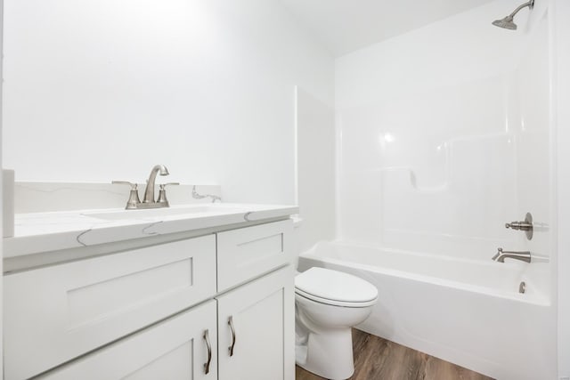 full bathroom featuring hardwood / wood-style flooring, shower / bathtub combination, vanity, and toilet