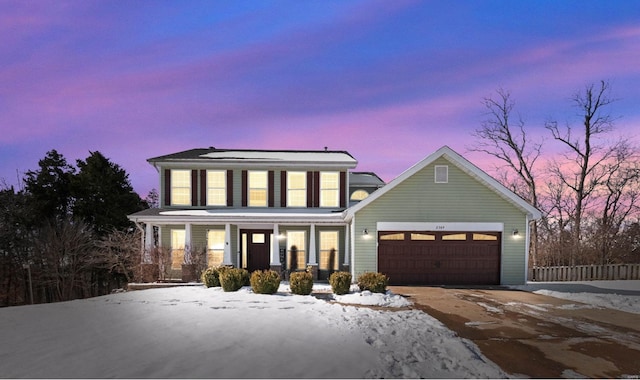 view of front facade featuring a garage, covered porch, and driveway