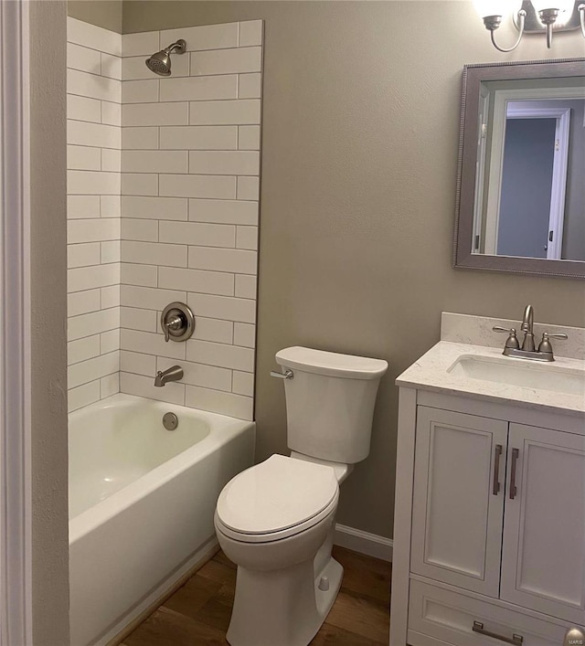 full bathroom featuring tiled shower / bath, vanity, toilet, and hardwood / wood-style floors