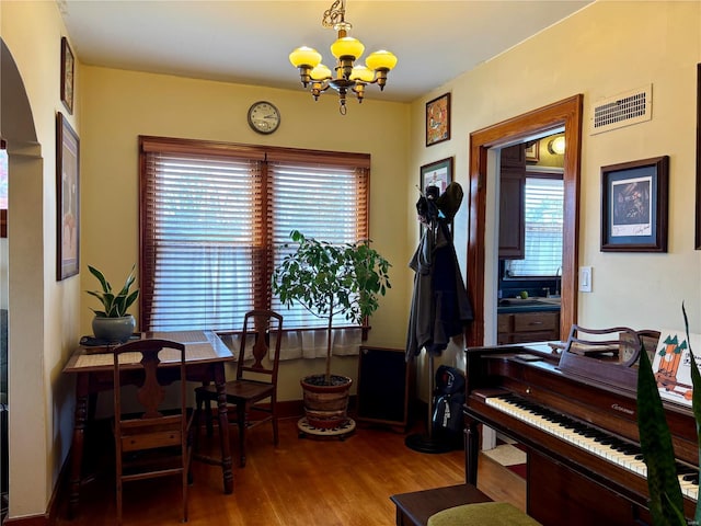 interior space featuring visible vents, a chandelier, and wood finished floors