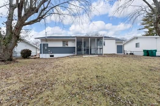 back of property featuring a sunroom and a yard