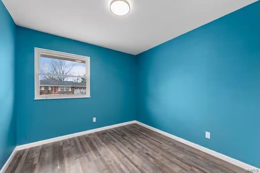 empty room featuring baseboards and wood finished floors